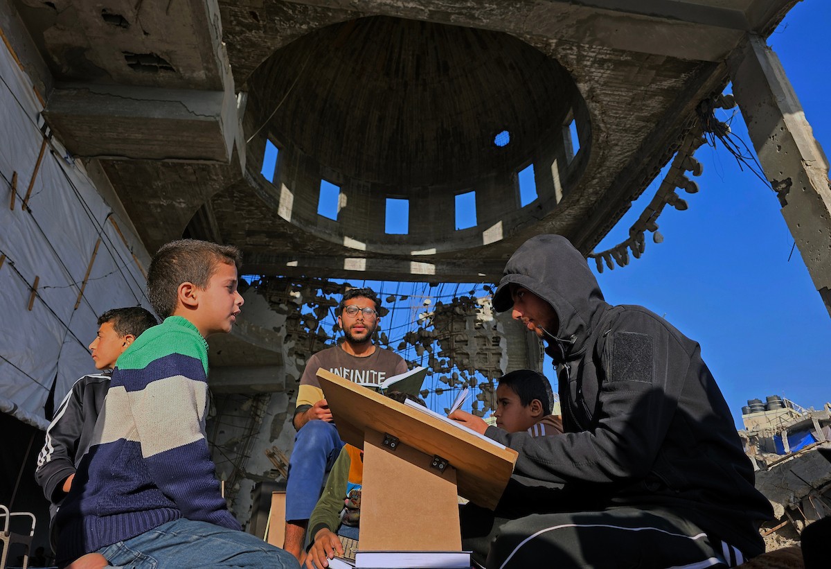 فلسطينيون، بينهم أطفال، يتلون ويحفظون القرآن الكريم خلال شهر رمضان داخل مسجد الألباني، الذي تضرر بشدة جراء الهجمات الإسرائيلية، في خان يونس، جنوب قطاع غزة، في 23 فبراير/شباط 2026. صورة: طارق محمد