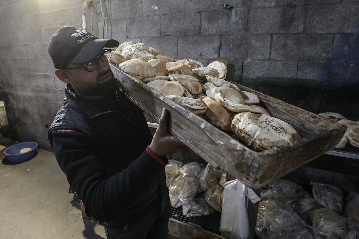 نساء فلسطينيات، زوجات شهداء الحرب، يُجهّزن الخبز لتوزيعه على العائلات النازحة والمحتاجة في مخيم البريج للاجئين وسط قطاع غزة خلال شهر رمضان، في مشهد يُجسّد روح التضامن والصمود في ظلّ الظروف الإنسانية الصعبة، فبراير/شباط 2026. تصوير: معز صالحي