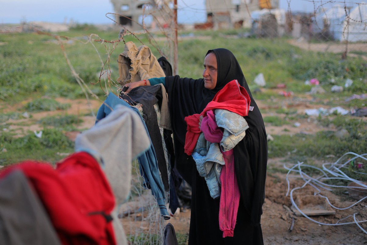 عائلة فلسطينية كفيفة تتناول وجبة الإفطار خارج خيمتها في مخيم بوسط قطاع غزة خلال شهر رمضان