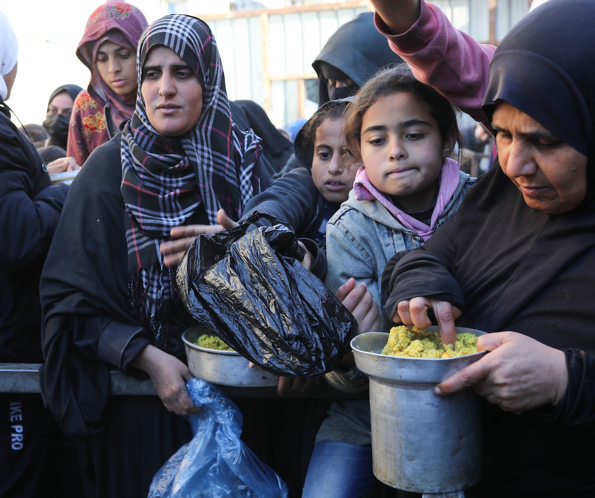 يتجمع فلسطينيون نازحون لتناول وجبة إفطارهم الرمضانية في مطبخ خيري بمخيم النصيرات للاجئين وسط قطاع غزة، في 24 فبراير/شباط 2026. ويواجه النازحون ظروفًا معيشية قاسية نتيجة انعدام الدخل ونقص المساعدات الإنسانية. (صورة: رمزي أبو عامر / apaimages)