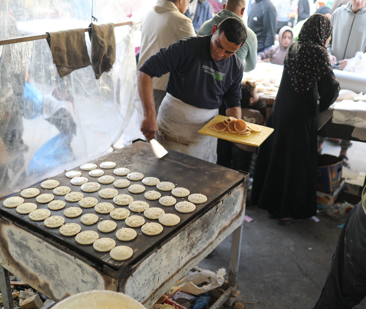 آلاء كريم نازحة في مخيم النصيرات وسط قطاع غزة، تفتح كشكًا لتحضير وبيع القطايف خلال أيام رمضان، في محاولة منها للتغلب على ظروف المعيشة القاسية وإعالة أسرتها بعد أن فقدت منزلها، 19 فبرايرشباط 2026. تصوير رمزي أبو عامر