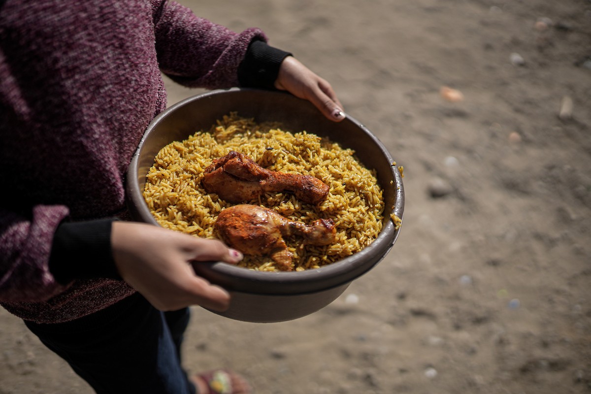 فلسطينيون بينهم أطفال ونساء يتلقون مساعدات غذائية وزعتها منظمات خيرية في أحد مراكز الإيواء بمدينة غزة، وسط أزمة غذائية مستمرة ناجمة عن محدودية المساعدات الإنسانية والظروف الإنسانية المتردية التي يواجهها النازحون، ١٢ فبراير/شباط ٢٠٢٦. تصوير: عمر أشتوي