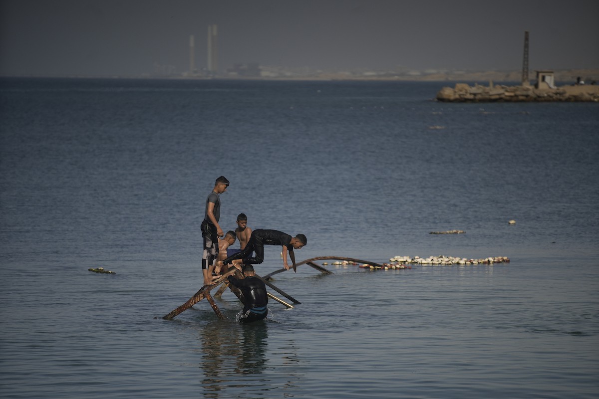 يسبح أطفال قرب ميناء غزة المدمر، في مشهد يعكس تمسكهم بلحظات الفرح رغم الدمار المحيط بهم. يُعدّ البحر في غزة المتنفس الوحيد لسكانها الذين يواجهون آثار الحرب والنزوح، والذين يعيشون في خيام تفتقر لأبسط مقومات الحياة، ١٢ فبراير ٢٠٢٦. تصوير: عمر أشتوي