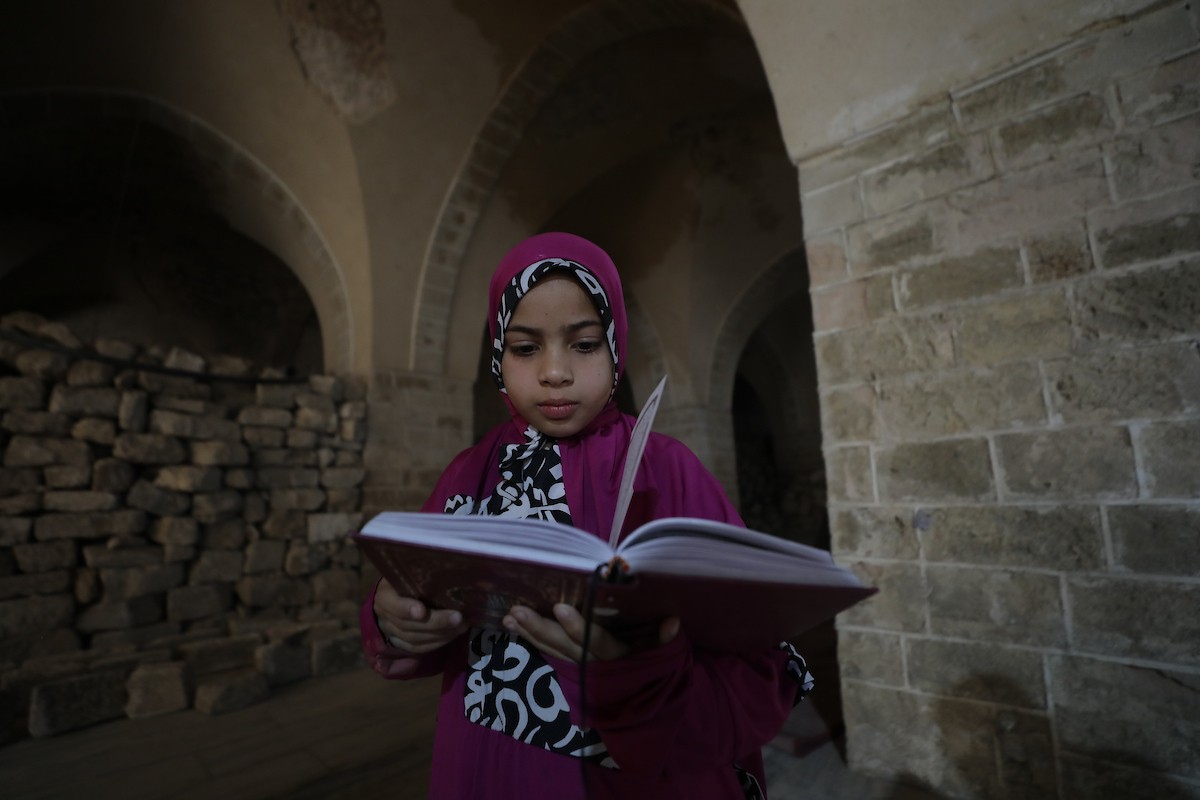 أطفال فلسطينيون يتلون ويحفظون القرآن الكريم داخل الجامع العمري الكبير في مدينة غزة خلال شهر رمضان. وقد تضرر الجامع العمري القديم بشدة جراء الهجمات الإسرائيلية خلال حرب غزة في 26 فبراير/شباط 2026. صورة: عمر أشتوي