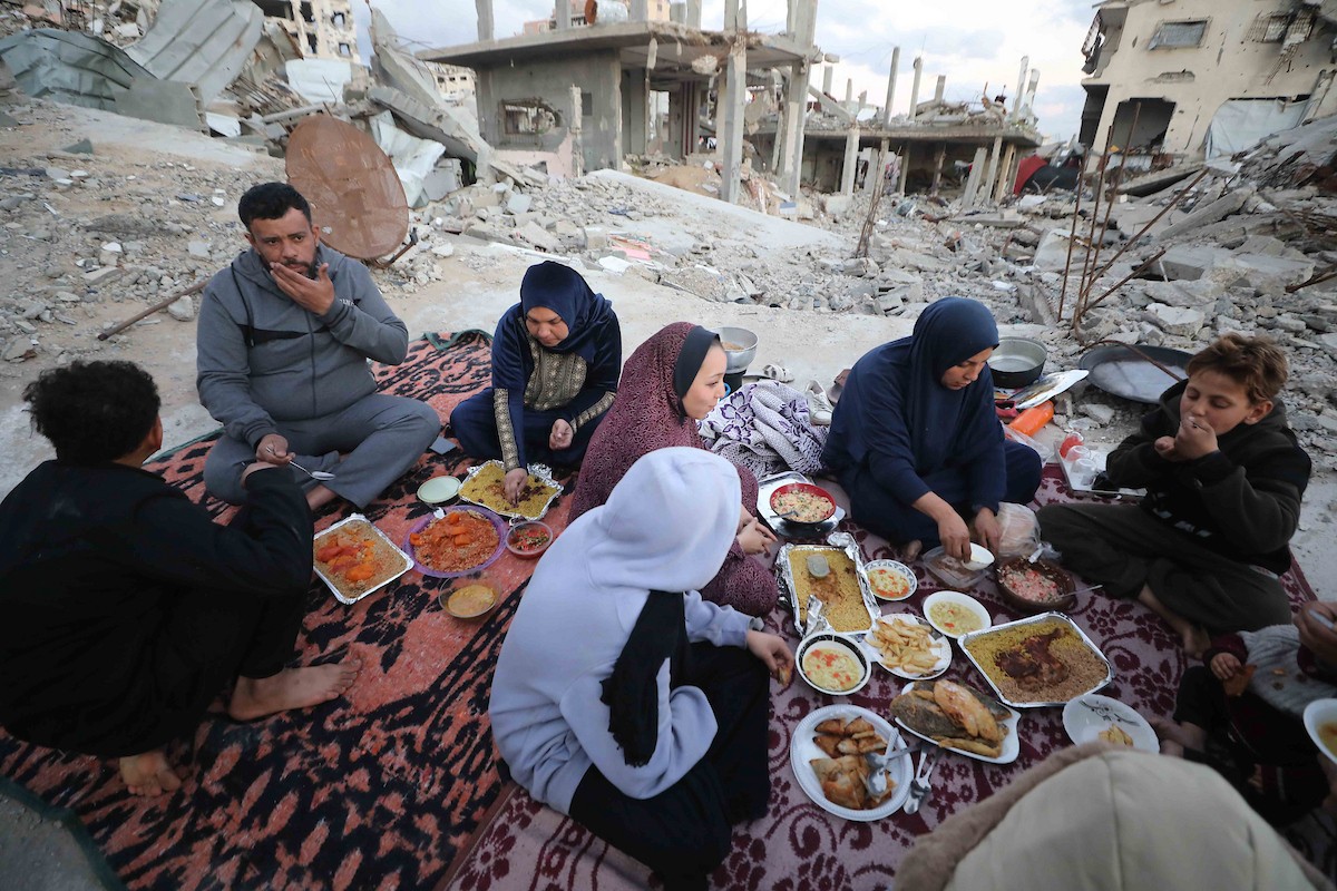 عائلة فلسطينية تتناول إفطارها خلال شهر رمضان على سطح منزلها الذي دمره قصف جوي إسرائيلي خلال حرب غزة في 27 فبراير/شباط 2026. صورة: عمر أشتوي