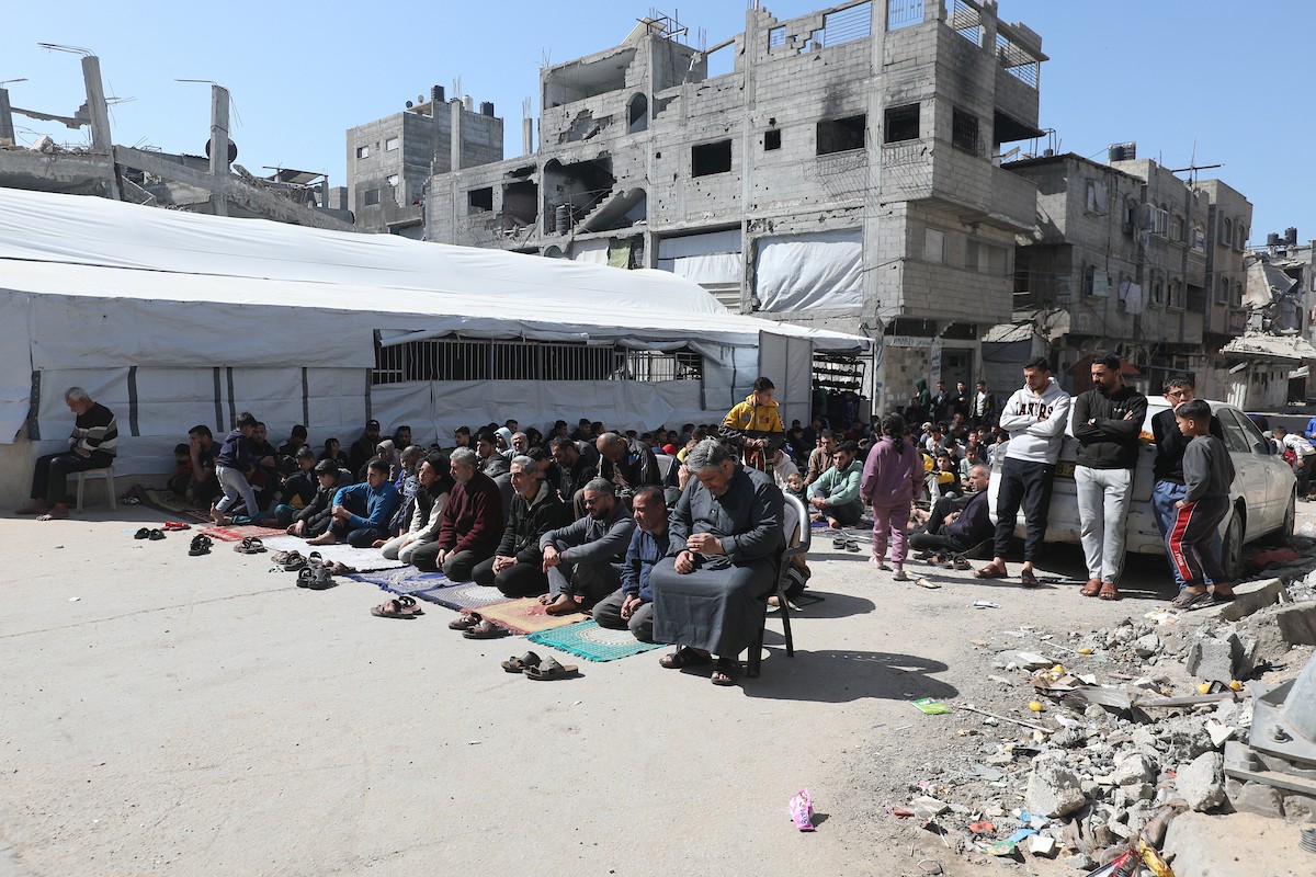 يؤدي النازحون أول صلاة جمعة في رمضان بجوار أنقاض مسجد الصفا المدمر بالكامل في مخيم البريج للاجئين وسط قطاع غزة. 20 فبراير/شباط 2026. تصوير: معز صالحي