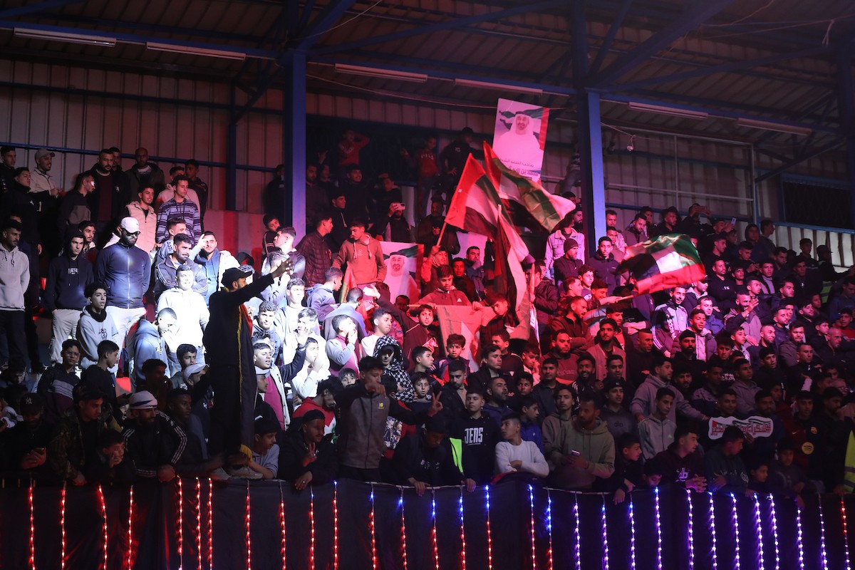 لاعبون فلسطينيون من فريقي النصيرات ورفح يتنافسون خلال مباراة كرة قدم على ملعب نادي خدمات النصيرات، ضمن بطولة غزة الرمضانية، بحضور حشد جماهيري كبير، في مخيم النصيرات بوسط قطاع غزة، بتاريخ 21 فبراير/شباط 2026. تصوير: معز صالحي / apaimages