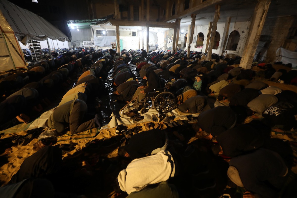 فلسطينيون يؤدون صلاة التراويح في أول ليلة من شهر رمضان على أنقاض مسجد الكنز المدمر في مدينة غزة، في 17 فبراير/شباط 2026. وكان مفتي القدس والأراضي الفلسطينية قد أعلن أن يوم الأربعاء 18 فبراير/شباط 2026 هو أول أيام رمضان. (صورة: عمر أشتوي)