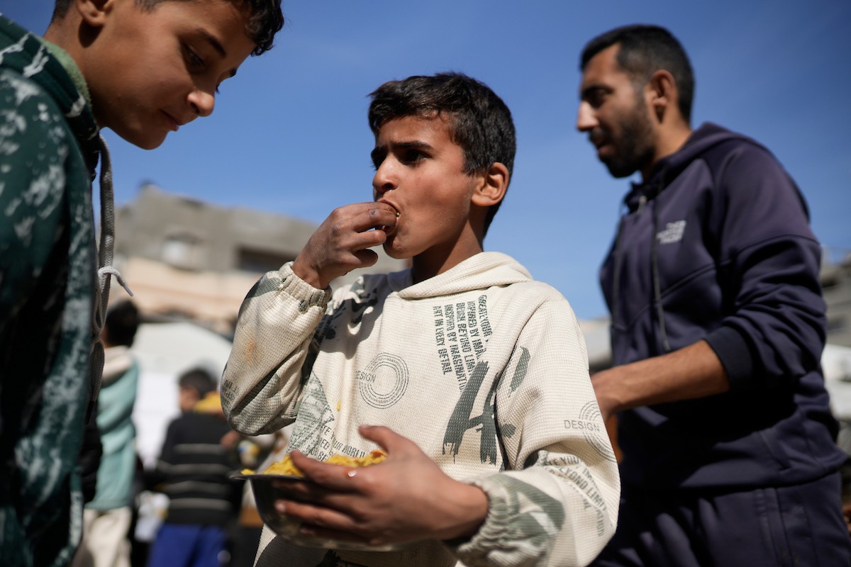 فلسطينيون بينهم أطفال ونساء يتلقون مساعدات غذائية وزعتها منظمات خيرية في أحد مراكز الإيواء بمدينة غزة، وسط أزمة غذائية مستمرة ناجمة عن محدودية المساعدات الإنسانية والظروف الإنسانية المتردية التي يواجهها النازحون، ١٢ فبراير/شباط ٢٠٢٦. تصوير: عمر أشتوي