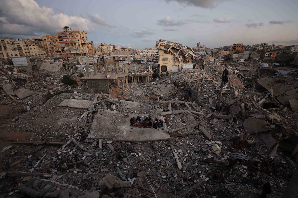 عائلة فلسطينية تتناول إفطارها خلال شهر رمضان على سطح منزلها الذي دمره قصف جوي إسرائيلي خلال حرب غزة في 27 فبراير/شباط 2026. صورة: عمر أشتوي