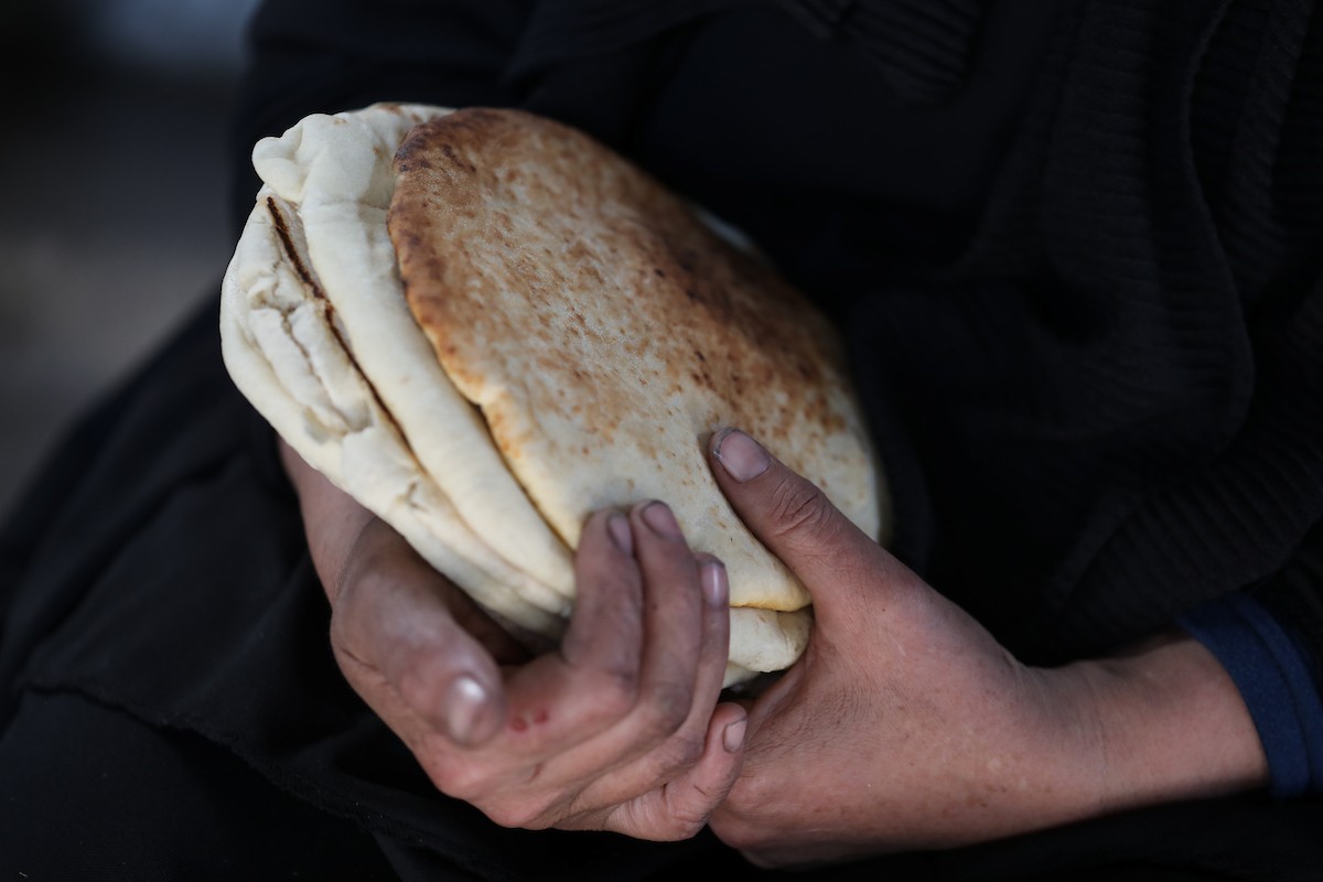 مجموعة من النساء يعملن داخل مخبز أُنشئ في مخيم اليرموك للاجئين بمدينة غزة، ضمن مبادرة إنسانية بالشراكة مع اللجنة الدولية للصليب الأحمر. تهدف المبادرة إلى تخفيف الأعباء المعيشية عن النساء النازحات، لا سيما خلال شهر رمضان. مدينة غزة، 25 فبراير/شباط 2026. تصوير: عمر أشتوي