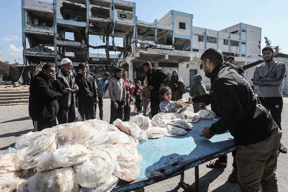 نساء فلسطينيات، زوجات شهداء الحرب، يُجهّزن الخبز لتوزيعه على العائلات النازحة والمحتاجة في مخيم البريج للاجئين وسط قطاع غزة خلال شهر رمضان، في مشهد يُجسّد روح التضامن والصمود في ظلّ الظروف الإنسانية الصعبة، فبراير/شباط 2026. تصوير: معز صالحي