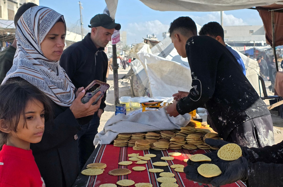 بائعٌ يُعدّ حلوى القطايف الشهيرة بالطرق التقليدية احتفالاً بشهر رمضان المبارك. ورغم الظروف المعيشية الصعبة، يواصل السكان شراء هذه الحلوى التقليدية. خان يونس، جنوب قطاع غزة، ٢٢ فبراير ٢٠٢٦. تصوير: طارق محمد