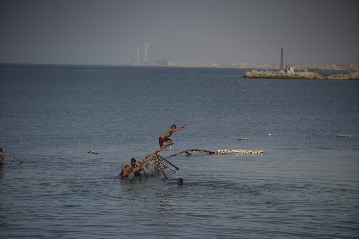 يسبح أطفال قرب ميناء غزة المدمر، في مشهد يعكس تمسكهم بلحظات الفرح رغم الدمار المحيط بهم. يُعدّ البحر في غزة المتنفس الوحيد لسكانها الذين يواجهون آثار الحرب والنزوح، والذين يعيشون في خيام تفتقر لأبسط مقومات الحياة، ١٢ فبراير ٢٠٢٦. تصوير: عمر أشتوي