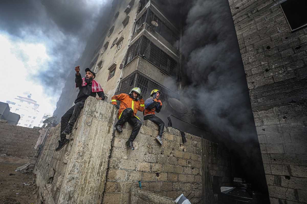 طواقم الدفاع المدني ومتطوعون من المواطنين أثناء محاولة إخماد حريق اندلع في مستودع تابع لمنظمة إغاثة في حي الرمال، غرب مدينة غزة، في 13 فبراير/شباط 2026. صورة: عمر أشتوي