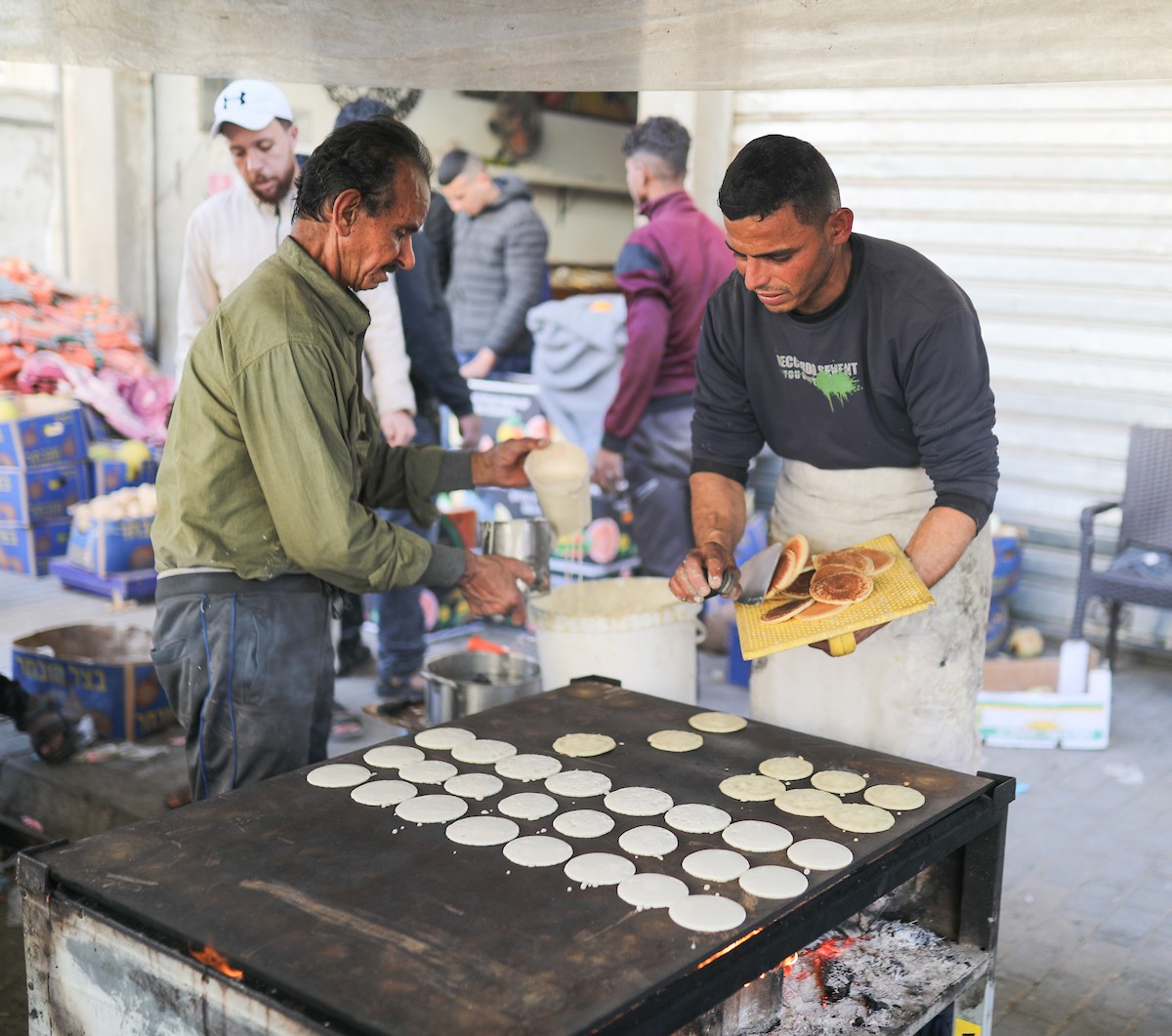 آلاء كريم نازحة في مخيم النصيرات وسط قطاع غزة، تفتح كشكًا لتحضير وبيع القطايف خلال أيام رمضان، في محاولة منها للتغلب على ظروف المعيشة القاسية وإعالة أسرتها بعد أن فقدت منزلها، 19 فبرايرشباط 2026. تصوير رمزي أبو عامر
