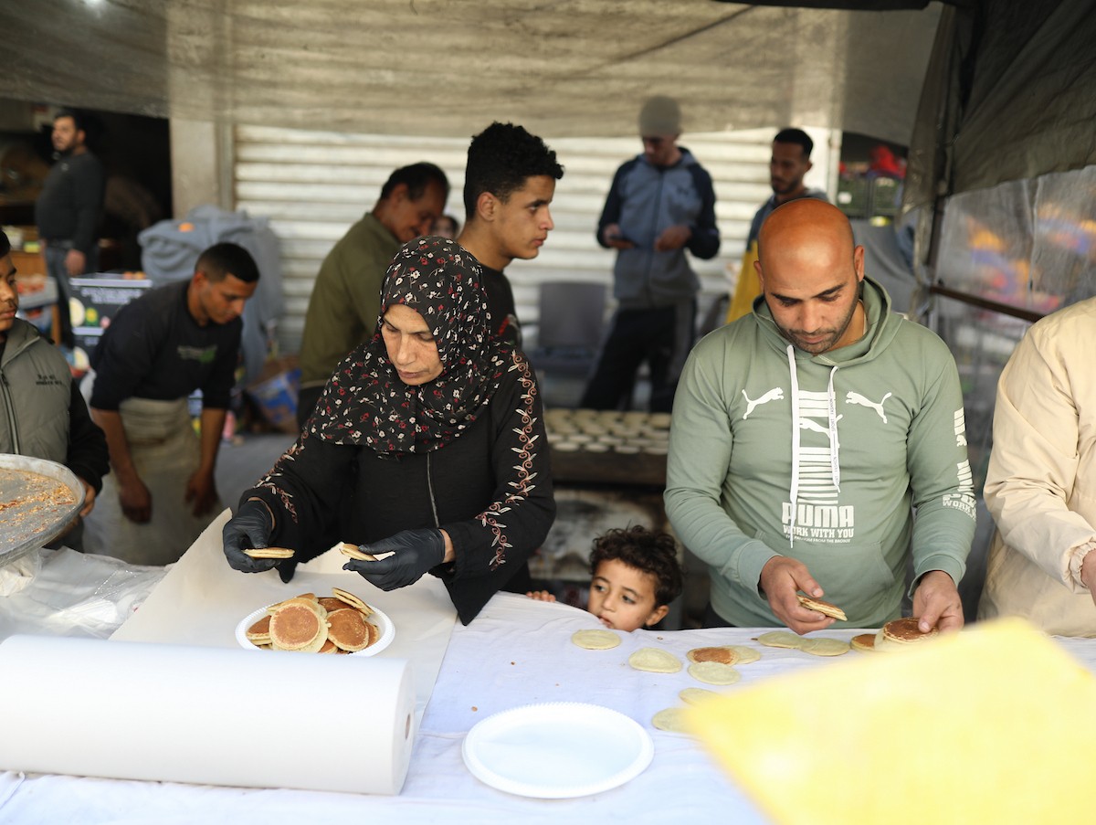 آلاء كريم نازحة في مخيم النصيرات وسط قطاع غزة، تفتح كشكًا لتحضير وبيع القطايف خلال أيام رمضان، في محاولة منها للتغلب على ظروف المعيشة القاسية وإعالة أسرتها بعد أن فقدت منزلها، 19 فبرايرشباط 2026. تصوير رمزي أبو عامر