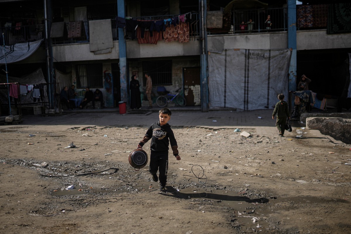 فلسطينيون بينهم أطفال ونساء يتلقون مساعدات غذائية وزعتها منظمات خيرية في أحد مراكز الإيواء بمدينة غزة، وسط أزمة غذائية مستمرة ناجمة عن محدودية المساعدات الإنسانية والظروف الإنسانية المتردية التي يواجهها النازحون، ١٢ فبراير/شباط ٢٠٢٦. تصوير: عمر أشتوي