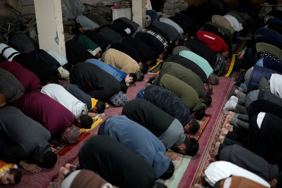 فلسطينيون يؤدون صلاة التراويح في أول ليلة من شهر رمضان على أنقاض مسجد الكنز المدمر في مدينة غزة، في 17 فبراير/شباط 2026. وكان مفتي القدس والأراضي الفلسطينية قد أعلن أن يوم الأربعاء 18 فبراير/شباط 2026 هو أول أيام رمضان. (صورة: عمر أشتوي)