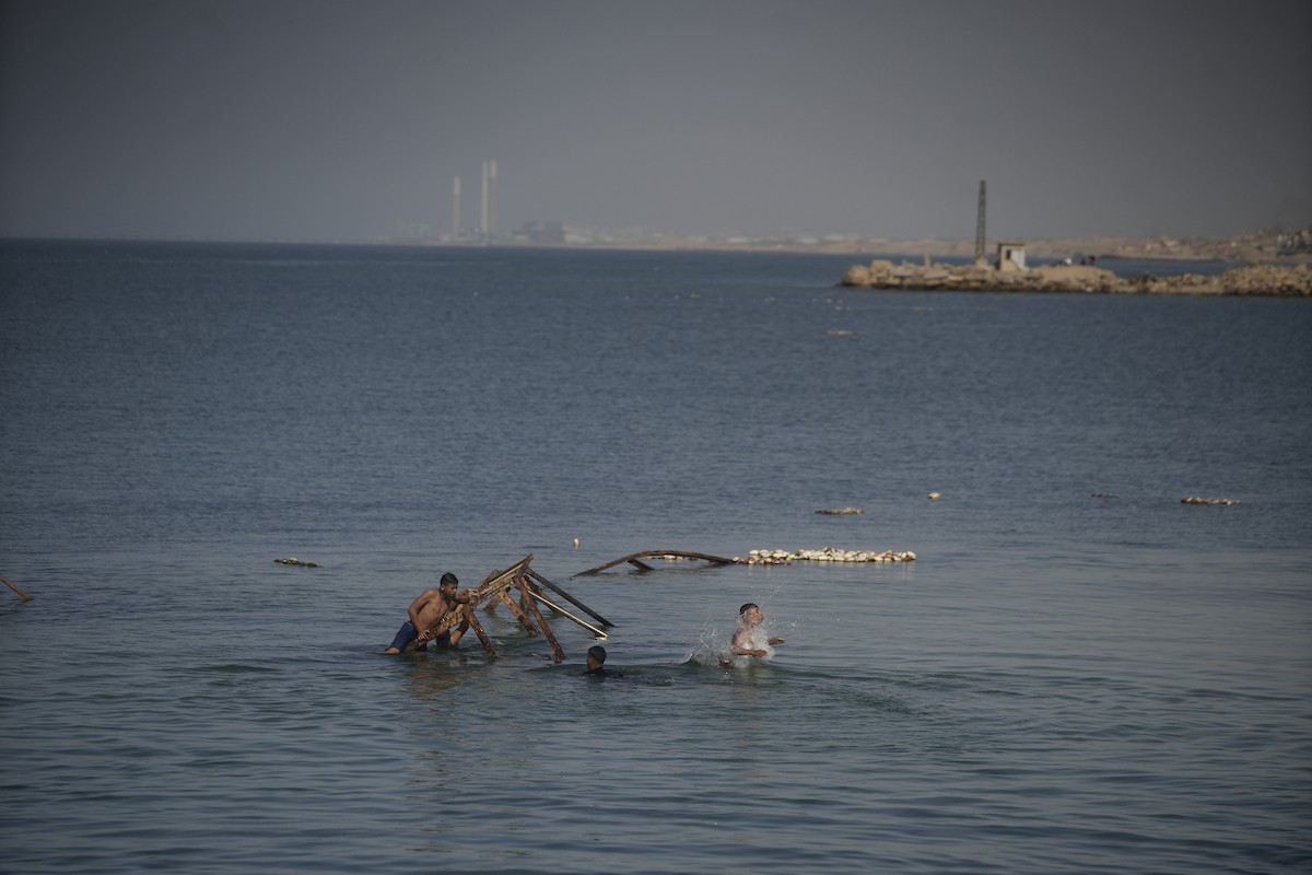 يسبح أطفال قرب ميناء غزة المدمر، في مشهد يعكس تمسكهم بلحظات الفرح رغم الدمار المحيط بهم. يُعدّ البحر في غزة المتنفس الوحيد لسكانها الذين يواجهون آثار الحرب والنزوح، والذين يعيشون في خيام تفتقر لأبسط مقومات الحياة، ١٢ فبراير ٢٠٢٦. تصوير: عمر أشتوي