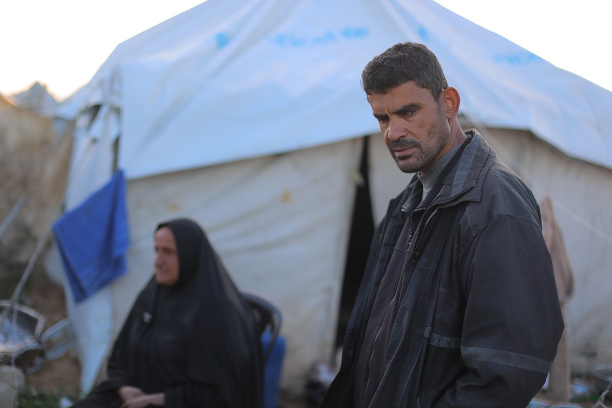 عائلة فلسطينية كفيفة تتناول وجبة الإفطار خارج خيمتها في مخيم بوسط قطاع غزة خلال شهر رمضان