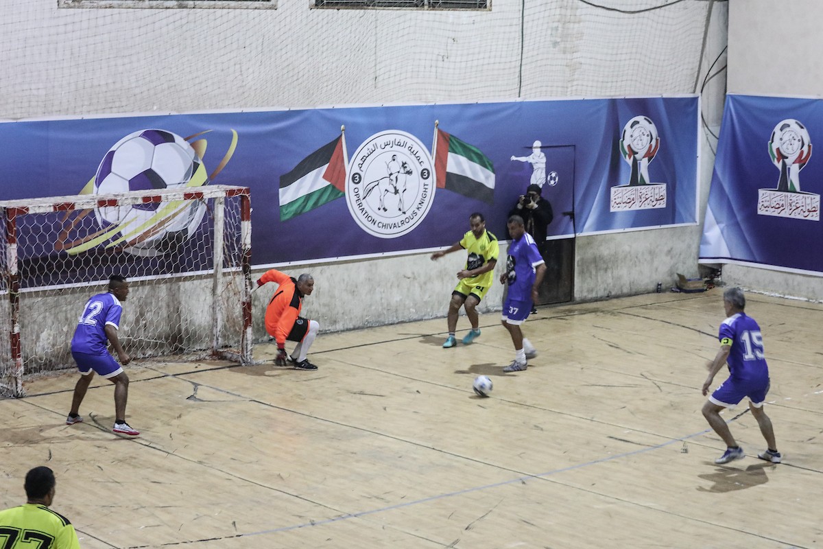 لاعبون فلسطينيون من فريقي النصيرات ورفح يتنافسون خلال مباراة كرة قدم على ملعب نادي خدمات النصيرات، ضمن بطولة غزة الرمضانية، بحضور حشد جماهيري كبير، في مخيم النصيرات بوسط قطاع غزة، بتاريخ 21 فبراير/شباط 2026. تصوير: معز صالحي / apaimages