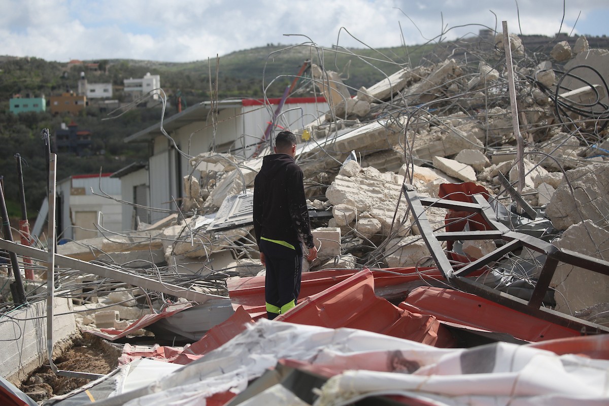 فلسطينيون يتفقدون منزلاً بعد هدمه على يد قوات الجيش الإسرائيلي في قرية عنزة، جنوب جنين بالضفة الغربية. ٢٥ فبراير ٢٠٢٦. صورة: محمد ناصر