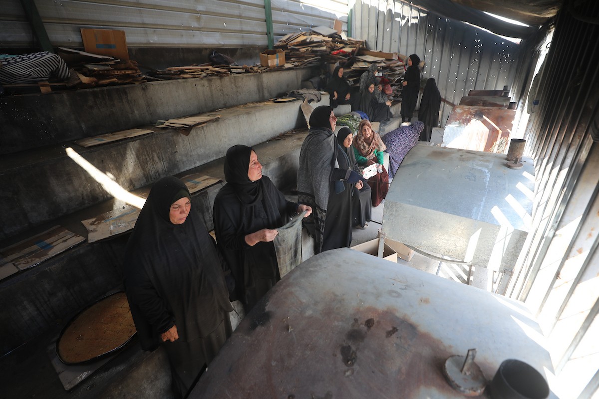 مجموعة من النساء يعملن داخل مخبز أُنشئ في مخيم اليرموك للاجئين بمدينة غزة، ضمن مبادرة إنسانية بالشراكة مع اللجنة الدولية للصليب الأحمر. تهدف المبادرة إلى تخفيف الأعباء المعيشية عن النساء النازحات، لا سيما خلال شهر رمضان. مدينة غزة، 25 فبراير/شباط 2026. تصوير: عمر أشتوي