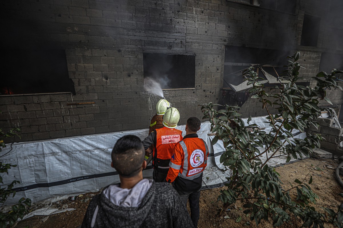 طواقم الدفاع المدني ومتطوعون من المواطنين أثناء محاولة إخماد حريق اندلع في مستودع تابع لمنظمة إغاثة في حي الرمال، غرب مدينة غزة، في 13 فبراير/شباط 2026. صورة: عمر أشتوي