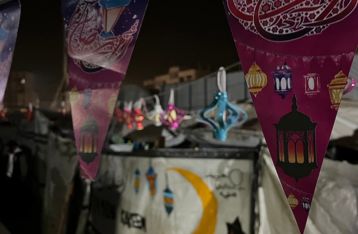 نازحون يزينون خيامهم المتهالكة بالفوانيس وسلاسل الأضواء استعدادًا لقدوم شهر رمضان. ويعانون ظروفًا قاسية نتيجة الحرب، إذ يفتقرون إلى أبسط مقومات الحياة، بما في ذلك المأوى الآمن والغذاء والماء والملابس النظيفة. ١٥ فبراير ٢٠٢٦، مدينة غزة. تصوير: مطر الزاق