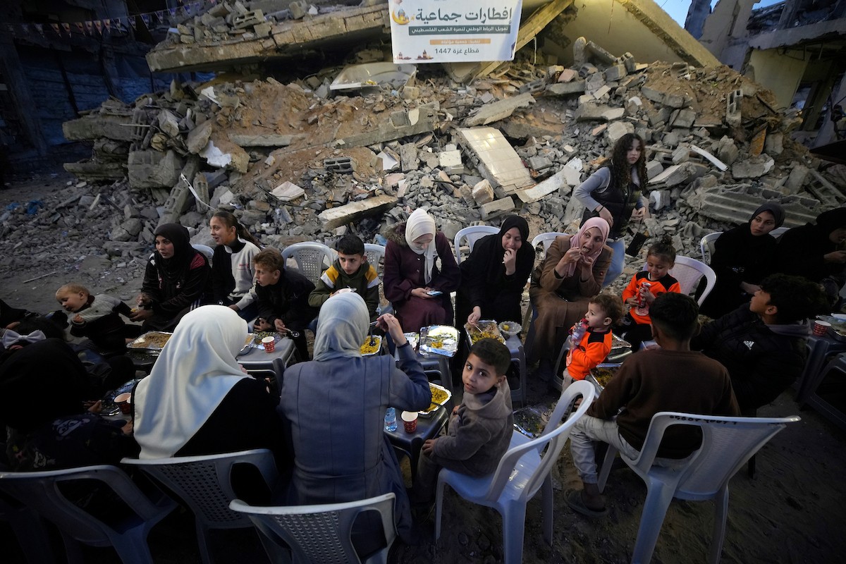 يتجمع الفلسطينيون بين المنازل المدمرة لتناول وجبة الإفطار معًا خلال شهر رمضان المبارك في شمال قطاع غزة، 22 فبراير/شباط 2026. صورة: عمر أشتوي