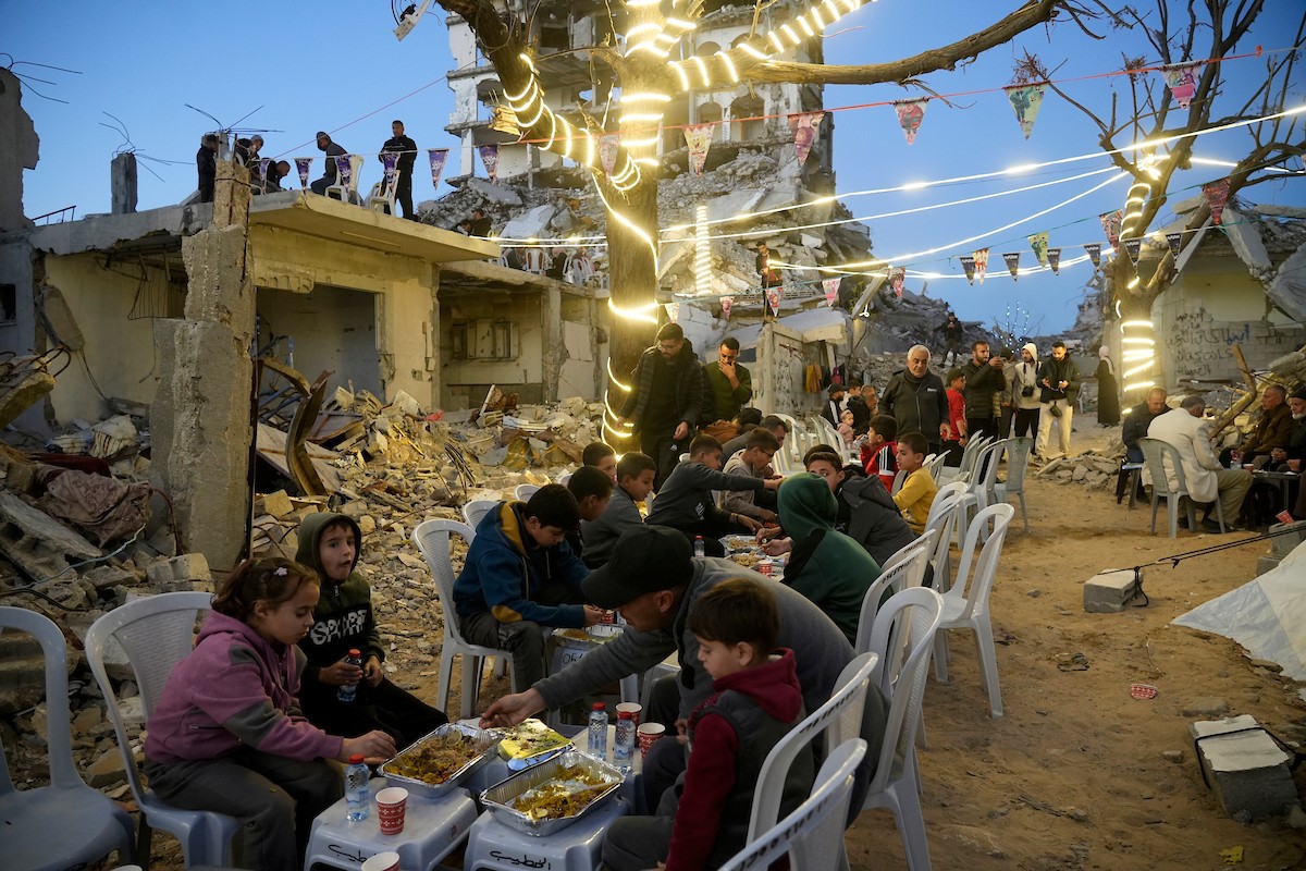 يتجمع الفلسطينيون بين المنازل المدمرة لتناول وجبة الإفطار معًا خلال شهر رمضان المبارك في شمال قطاع غزة، 22 فبراير/شباط 2026. صورة: عمر أشتوي