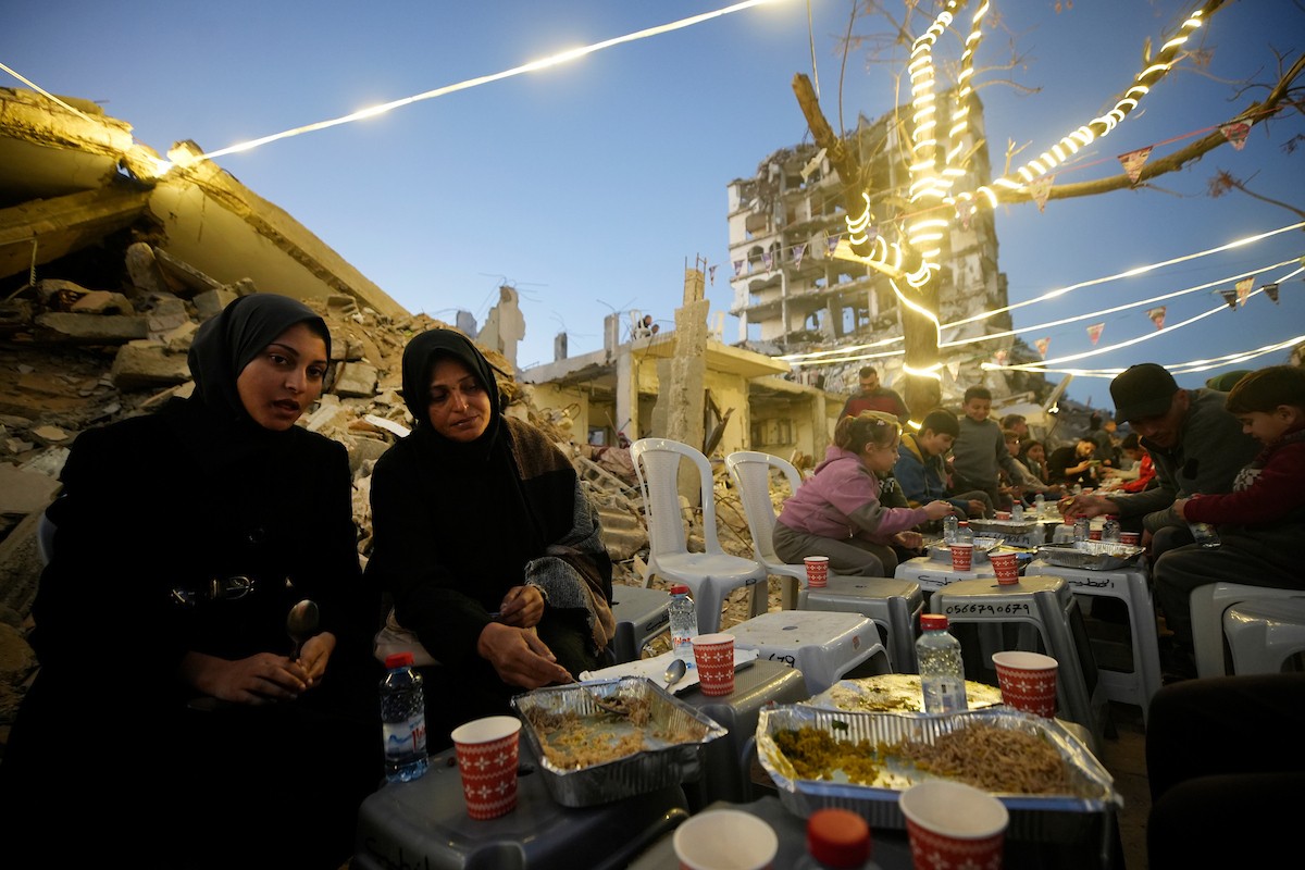 يتجمع الفلسطينيون بين المنازل المدمرة لتناول وجبة الإفطار معًا خلال شهر رمضان المبارك في شمال قطاع غزة، 22 فبراير/شباط 2026. صورة: عمر أشتوي