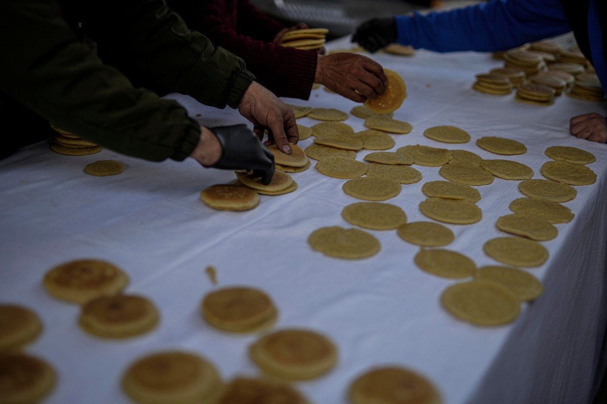 يتسوق الفلسطينيون في أول ليلة من شهر رمضان المبارك في سوق الزاوية، الواقع في قلب مدينة غزة والذي تضرر بشدة جراء الحرب الإسرائيلية. يعرض الباعة بضائعهم على أكشاك مزينة بالفوانيس والأضواء وأطعمة رمضان. مدينة غزة، 17 فبراير/شباط 2026. تصوير: عمر أشتوي