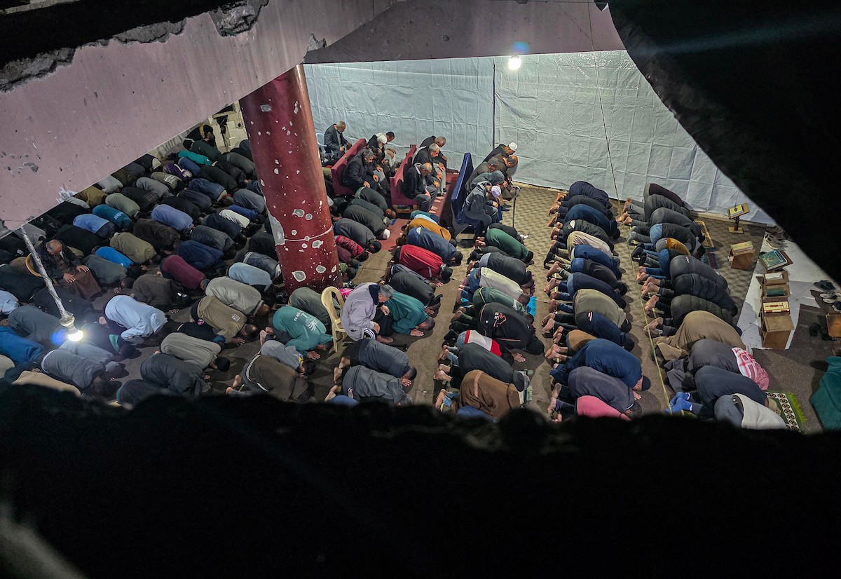 تجمّع المصلون في مسجد الفاروق المتضرر بشدة لأداء أول صلاة تراويح في شهر رمضان المبارك، رغم الدمار الذي خلفته الهجمات الإسرائيلية في خان يونس، جنوب قطاع غزة، في 17 فبراير/شباط 2026. صورة: تامر إبراهيم