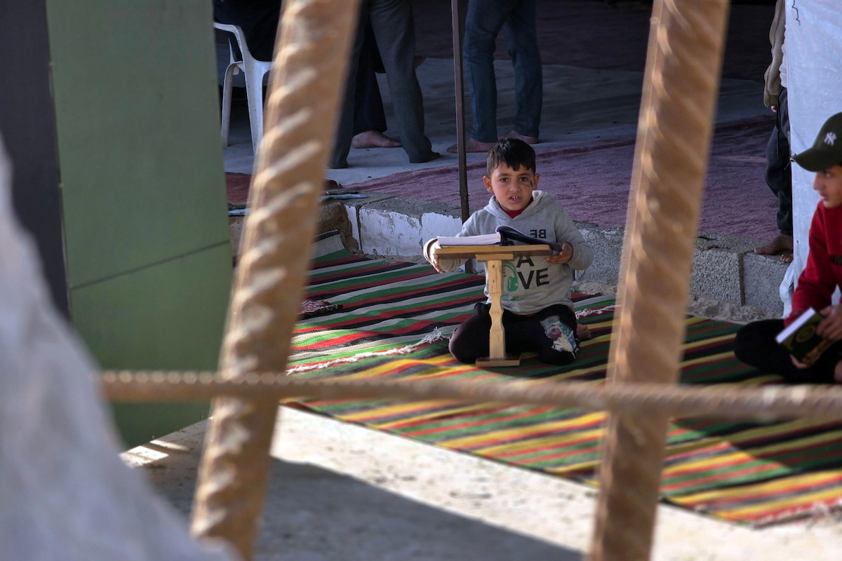 فلسطينيون، بينهم أطفال، يتلون ويحفظون القرآن الكريم خلال شهر رمضان داخل مسجد الألباني، الذي تضرر بشدة جراء الهجمات الإسرائيلية، في خان يونس، جنوب قطاع غزة، في 23 فبراير/شباط 2026. صورة: طارق محمد