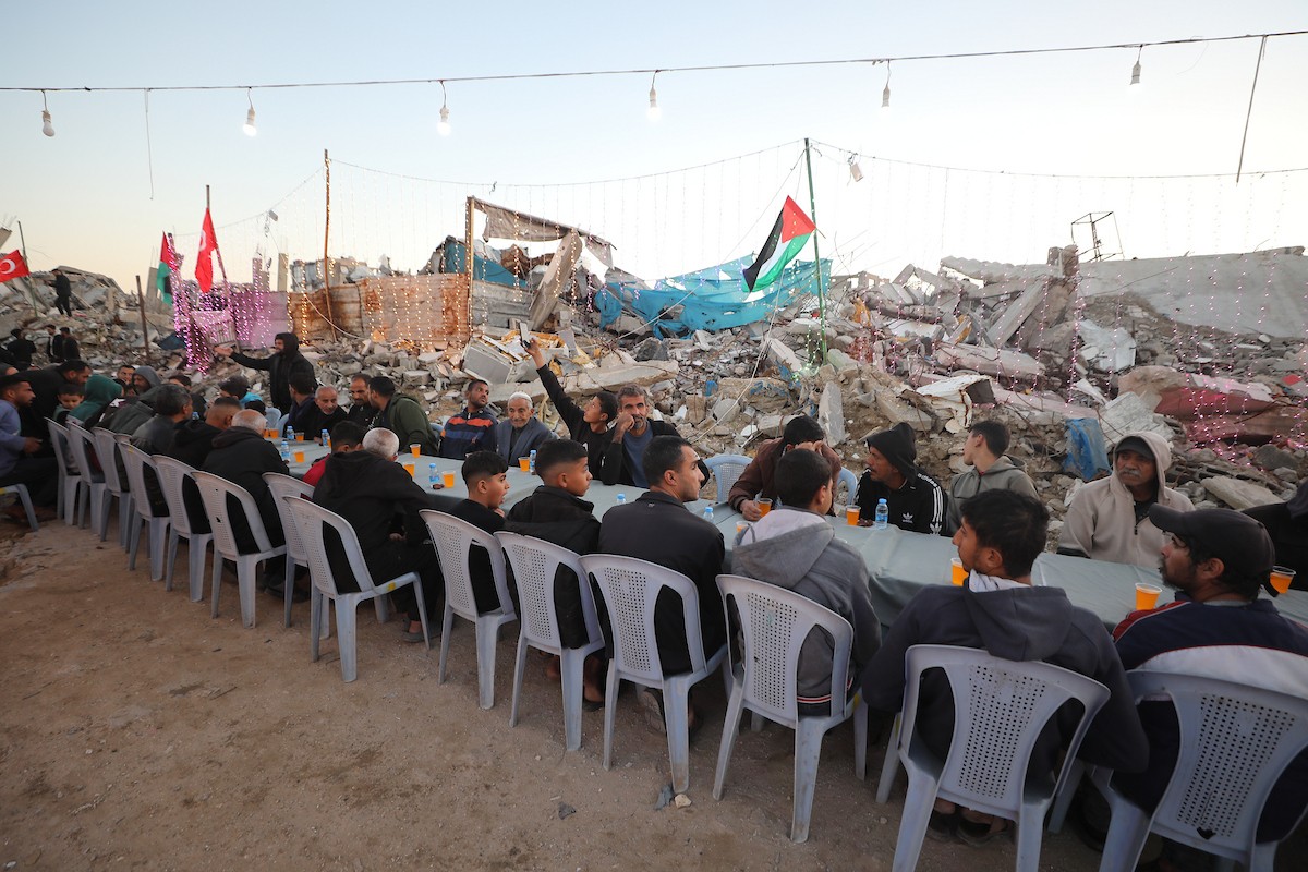يتجمع فلسطينيون نازحون لتناول وجبة الإفطار وسط أنقاض المباني المدمرة في مدينة غزة، خلال شهر رمضان المبارك، في 25 فبراير/شباط 2026. صورة: عمر أشتوي