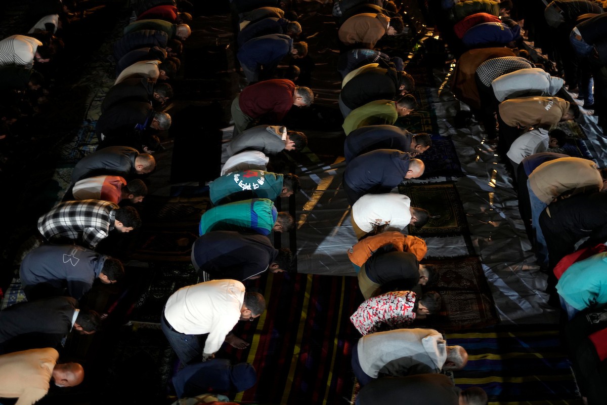 فلسطينيون يؤدون صلاة التراويح في أول ليلة من شهر رمضان على أنقاض مسجد الكنز المدمر في مدينة غزة، في 17 فبراير/شباط 2026. وكان مفتي القدس والأراضي الفلسطينية قد أعلن أن يوم الأربعاء 18 فبراير/شباط 2026 هو أول أيام رمضان. (صورة: عمر أشتوي)