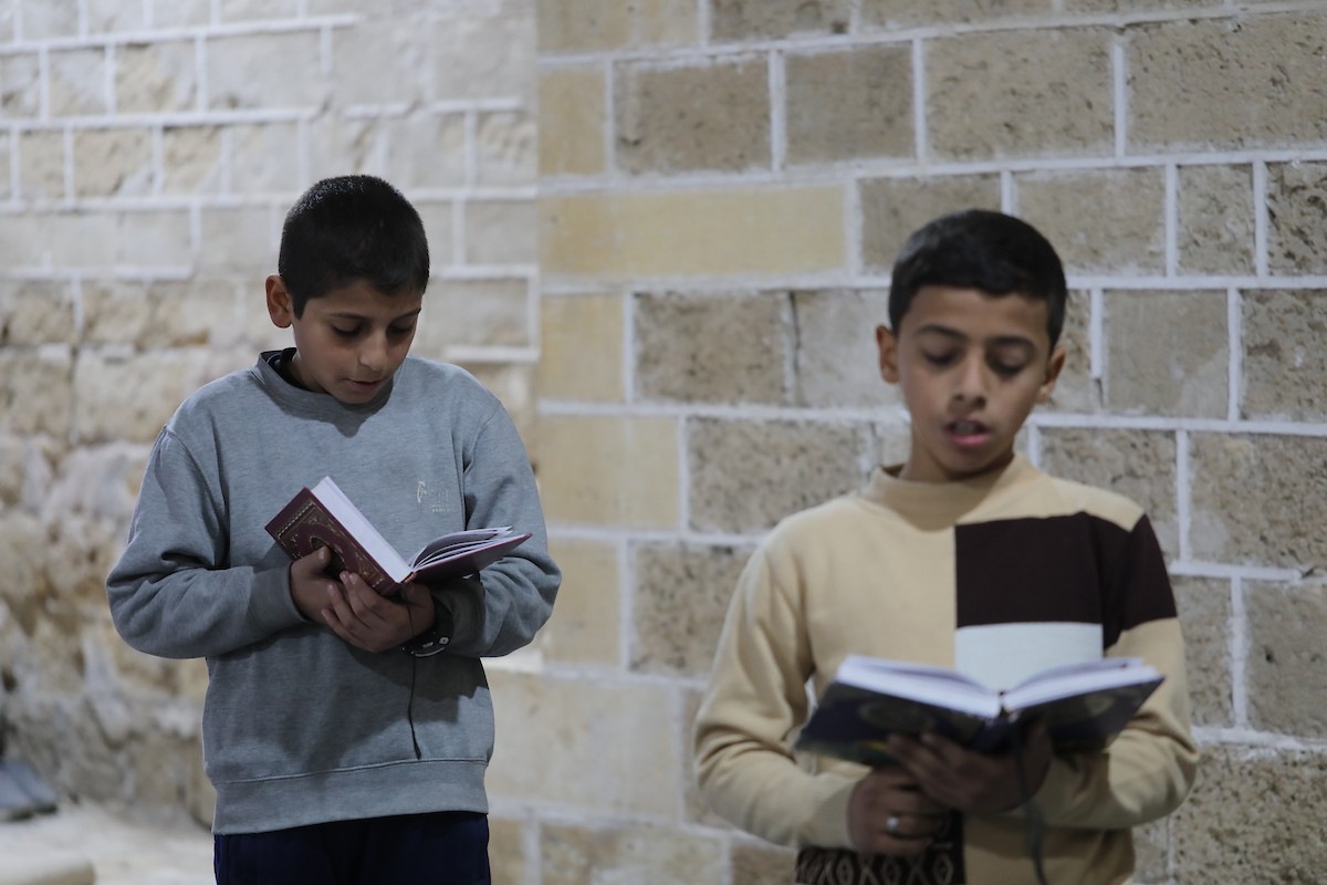 أطفال فلسطينيون يتلون ويحفظون القرآن الكريم داخل الجامع العمري الكبير في مدينة غزة خلال شهر رمضان. وقد تضرر الجامع العمري القديم بشدة جراء الهجمات الإسرائيلية خلال حرب غزة في 26 فبراير/شباط 2026. صورة: عمر أشتوي