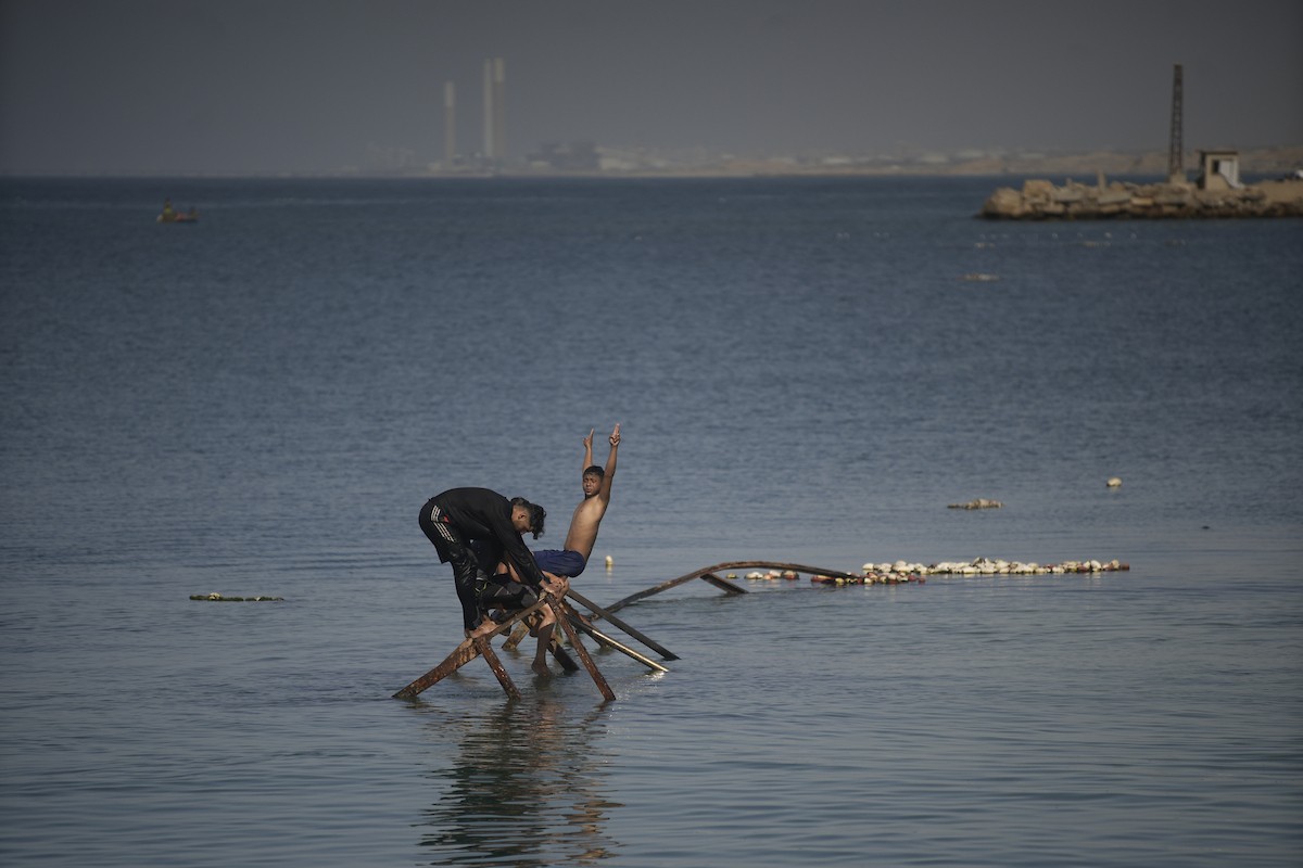 يسبح أطفال قرب ميناء غزة المدمر، في مشهد يعكس تمسكهم بلحظات الفرح رغم الدمار المحيط بهم. يُعدّ البحر في غزة المتنفس الوحيد لسكانها الذين يواجهون آثار الحرب والنزوح، والذين يعيشون في خيام تفتقر لأبسط مقومات الحياة، ١٢ فبراير ٢٠٢٦. تصوير: عمر أشتوي