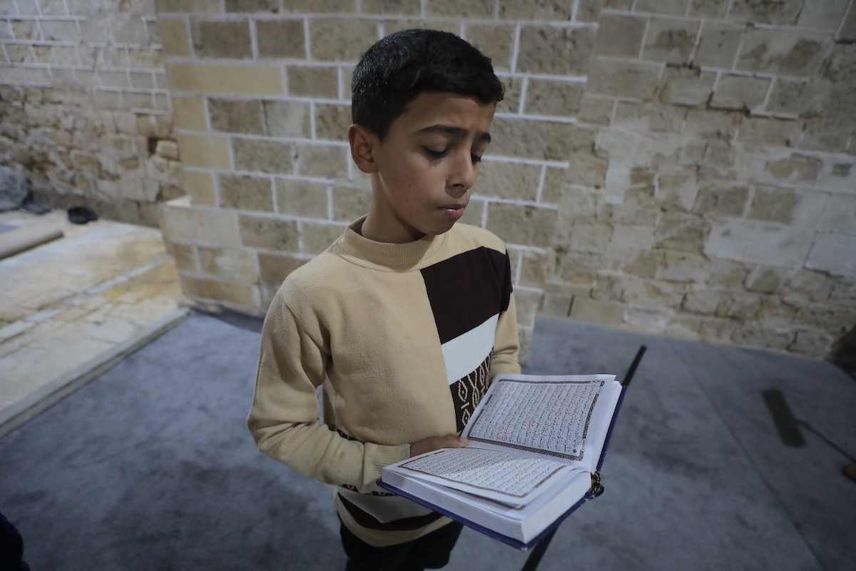 أطفال فلسطينيون يتلون ويحفظون القرآن الكريم داخل الجامع العمري الكبير في مدينة غزة خلال شهر رمضان. وقد تضرر الجامع العمري القديم بشدة جراء الهجمات الإسرائيلية خلال حرب غزة في 26 فبراير/شباط 2026. صورة: عمر أشتوي