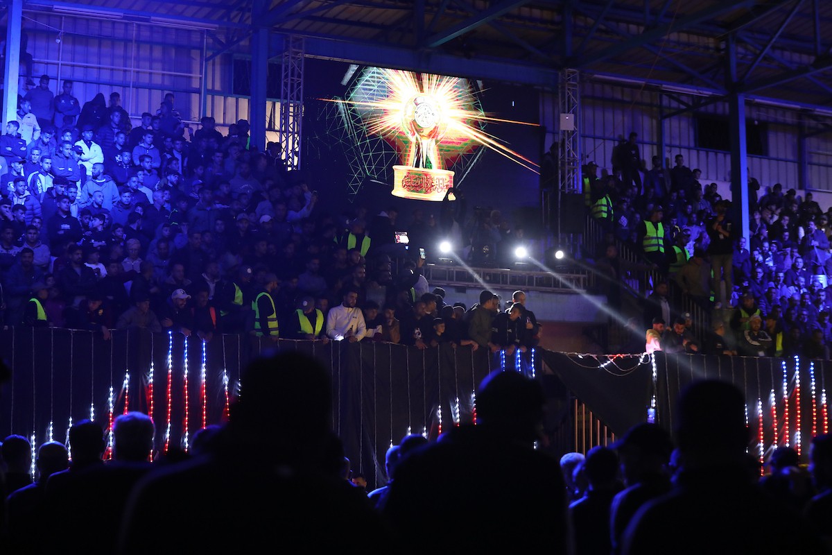 لاعبون فلسطينيون من فريقي النصيرات ورفح يتنافسون خلال مباراة كرة قدم على ملعب نادي خدمات النصيرات، ضمن بطولة غزة الرمضانية، بحضور حشد جماهيري كبير، في مخيم النصيرات بوسط قطاع غزة، بتاريخ 21 فبراير/شباط 2026. تصوير: معز صالحي / apaimages