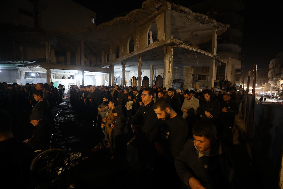 فلسطينيون يؤدون صلاة التراويح في أول ليلة من شهر رمضان على أنقاض مسجد الكنز المدمر في مدينة غزة، في 17 فبراير/شباط 2026. وكان مفتي القدس والأراضي الفلسطينية قد أعلن أن يوم الأربعاء 18 فبراير/شباط 2026 هو أول أيام رمضان. (صورة: عمر أشتوي)