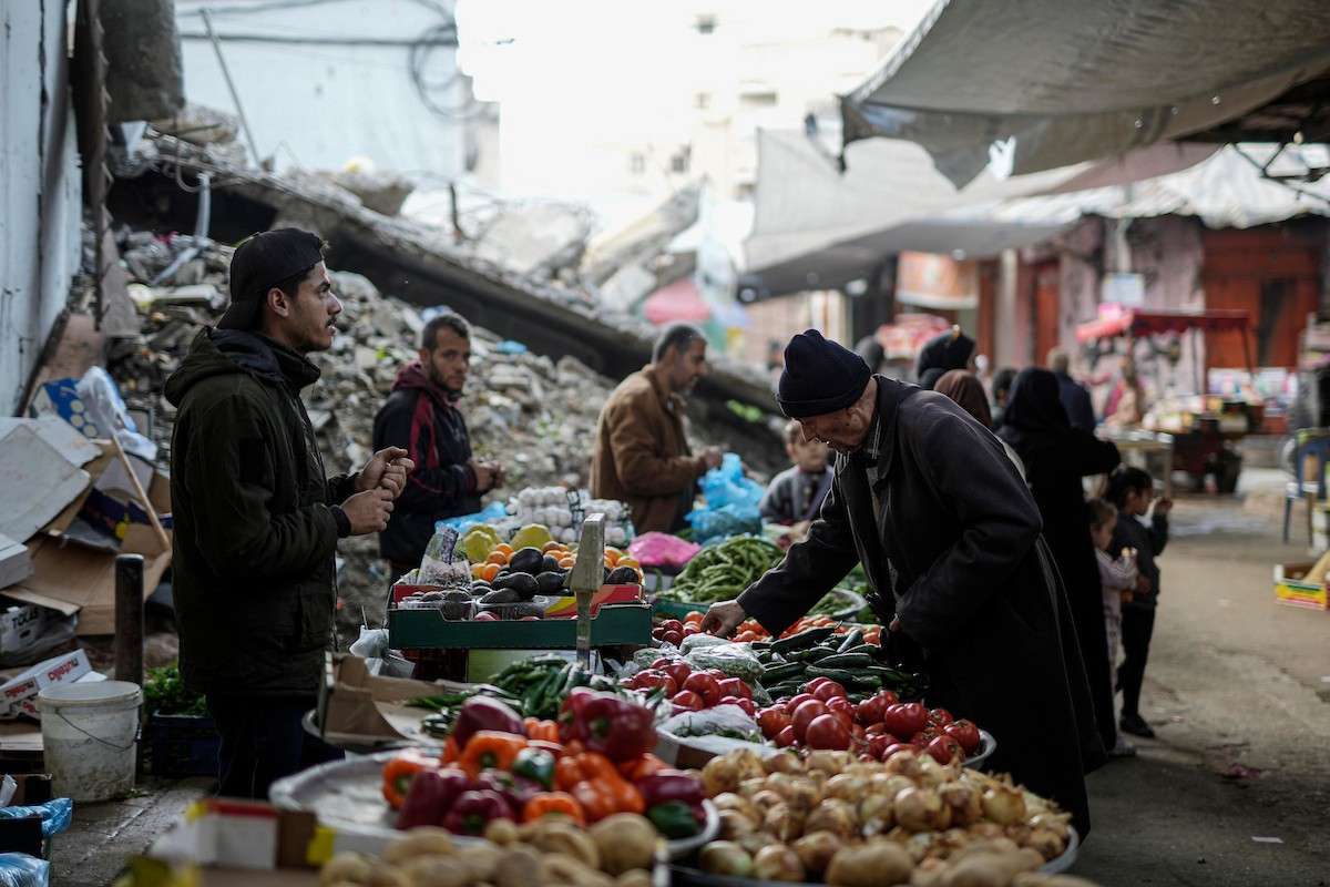 يتسوق الفلسطينيون في أول ليلة من شهر رمضان المبارك في سوق الزاوية، الواقع في قلب مدينة غزة والذي تضرر بشدة جراء الحرب الإسرائيلية. يعرض الباعة بضائعهم على أكشاك مزينة بالفوانيس والأضواء وأطعمة رمضان. مدينة غزة، 17 فبراير/شباط 2026. تصوير: عمر أشتوي