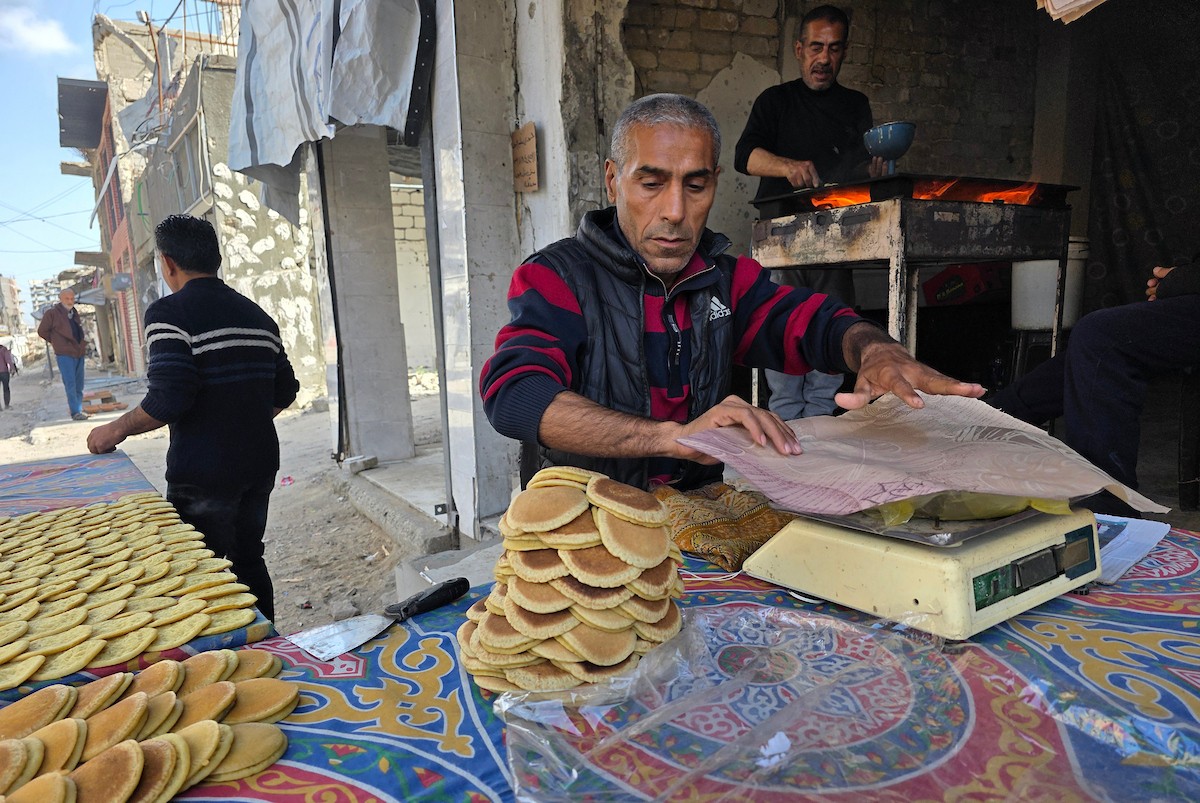 سليم البيوك ُيعدّ معجنات القطايف التقليدية باستخدام أساليب بدائية تعتمد على الحطب والنارمُواصلاً إحياء تقاليد شهر رمضان منذ أكثر من 20 عاماً، في سوق كراج رفح في خان يونس، جنوب قطاع غزة، في 12 فبراير/شباط 2026.تصوير: طارق محمد