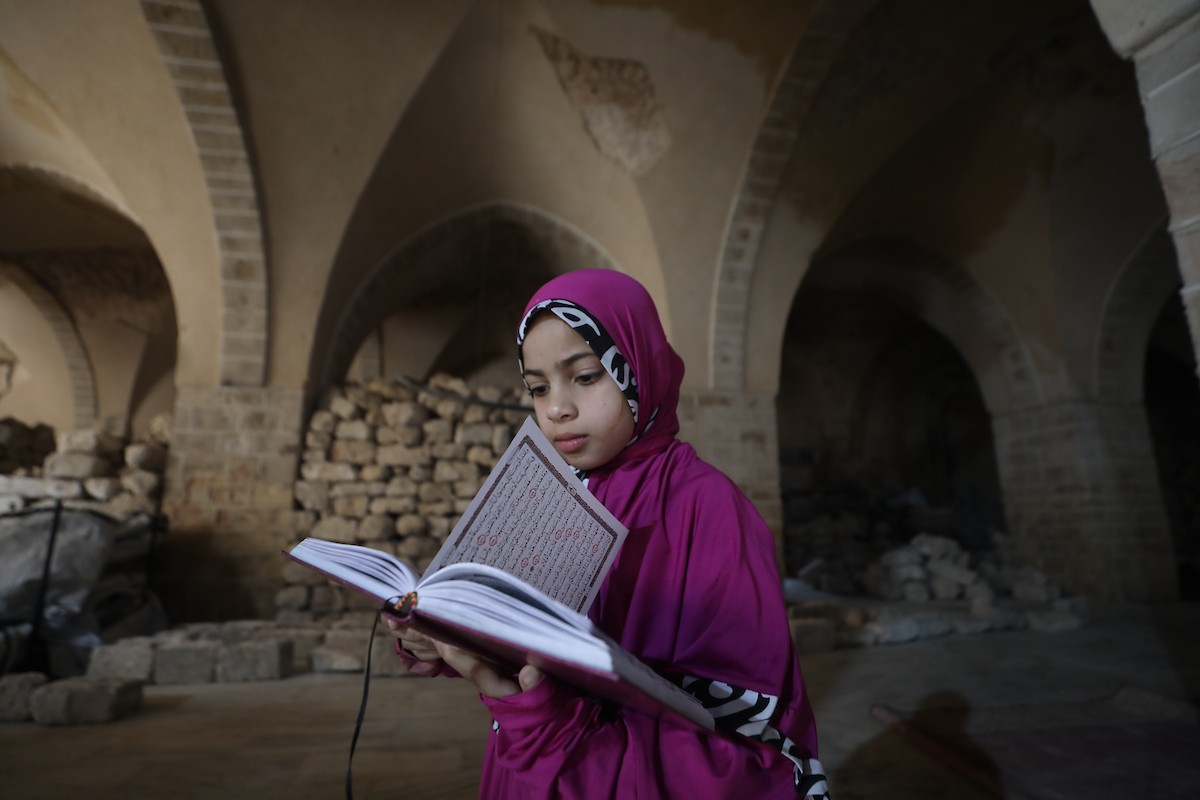أطفال فلسطينيون يتلون ويحفظون القرآن الكريم داخل الجامع العمري الكبير في مدينة غزة خلال شهر رمضان. وقد تضرر الجامع العمري القديم بشدة جراء الهجمات الإسرائيلية خلال حرب غزة في 26 فبراير/شباط 2026. صورة: عمر أشتوي