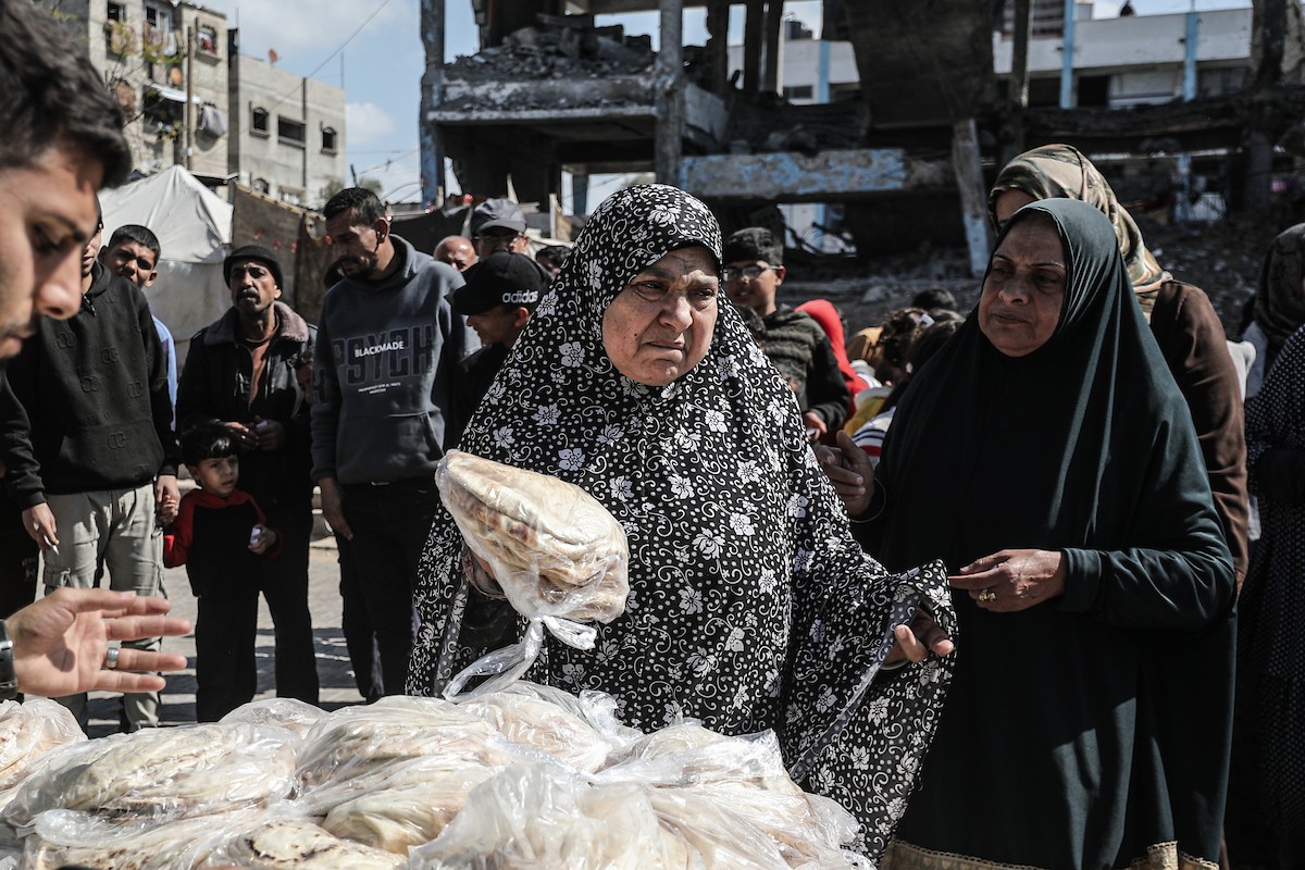 نساء فلسطينيات، زوجات شهداء الحرب، يُجهّزن الخبز لتوزيعه على العائلات النازحة والمحتاجة في مخيم البريج للاجئين وسط قطاع غزة خلال شهر رمضان، في مشهد يُجسّد روح التضامن والصمود في ظلّ الظروف الإنسانية الصعبة، فبراير/شباط 2026. تصوير: معز صالحي