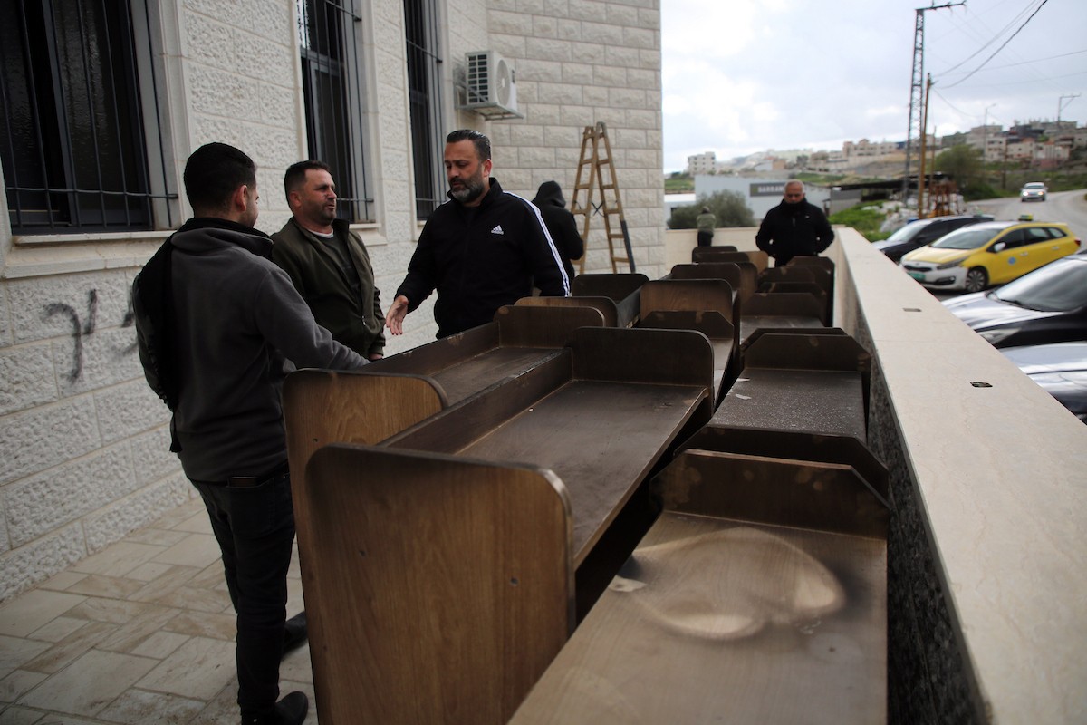 يتفقد فلسطينيون المدخل المحترق لمسجد أبو بكر الصديق في قرية تل، غرب نابلس بالضفة الغربية، في 23 فبراير/شباط 2026، عقب هجوم نُسب إلى مستوطنين يهود. صورة: محمد ناصر