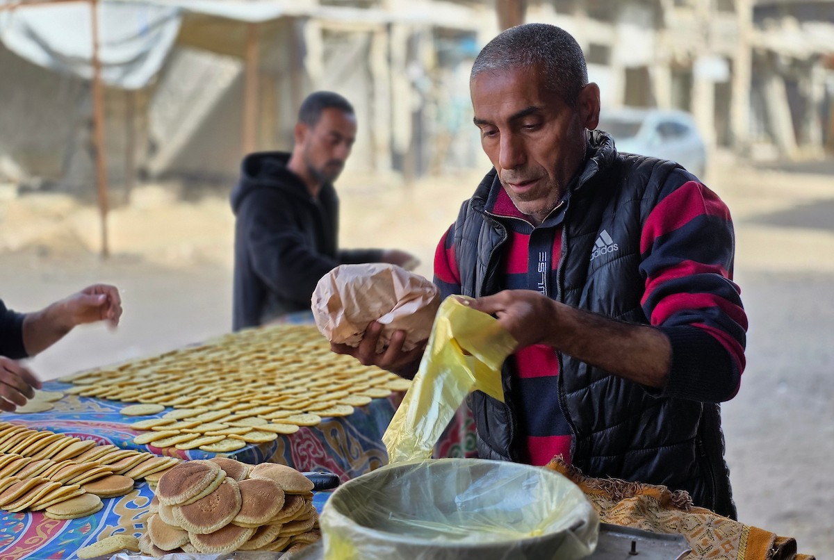 سليم البيوك ُيعدّ معجنات القطايف التقليدية باستخدام أساليب بدائية تعتمد على الحطب والنارمُواصلاً إحياء تقاليد شهر رمضان منذ أكثر من 20 عاماً، في سوق كراج رفح في خان يونس، جنوب قطاع غزة، في 12 فبراير/شباط 2026.تصوير: طارق محمد