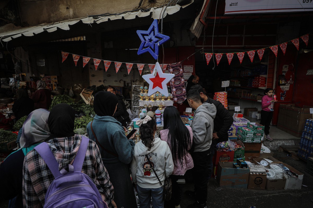 يتسوق الفلسطينيون في أول ليلة من شهر رمضان المبارك في سوق الزاوية، الواقع في قلب مدينة غزة والذي تضرر بشدة جراء الحرب الإسرائيلية. يعرض الباعة بضائعهم على أكشاك مزينة بالفوانيس والأضواء وأطعمة رمضان. مدينة غزة، 17 فبراير/شباط 2026. تصوير: عمر أشتوي